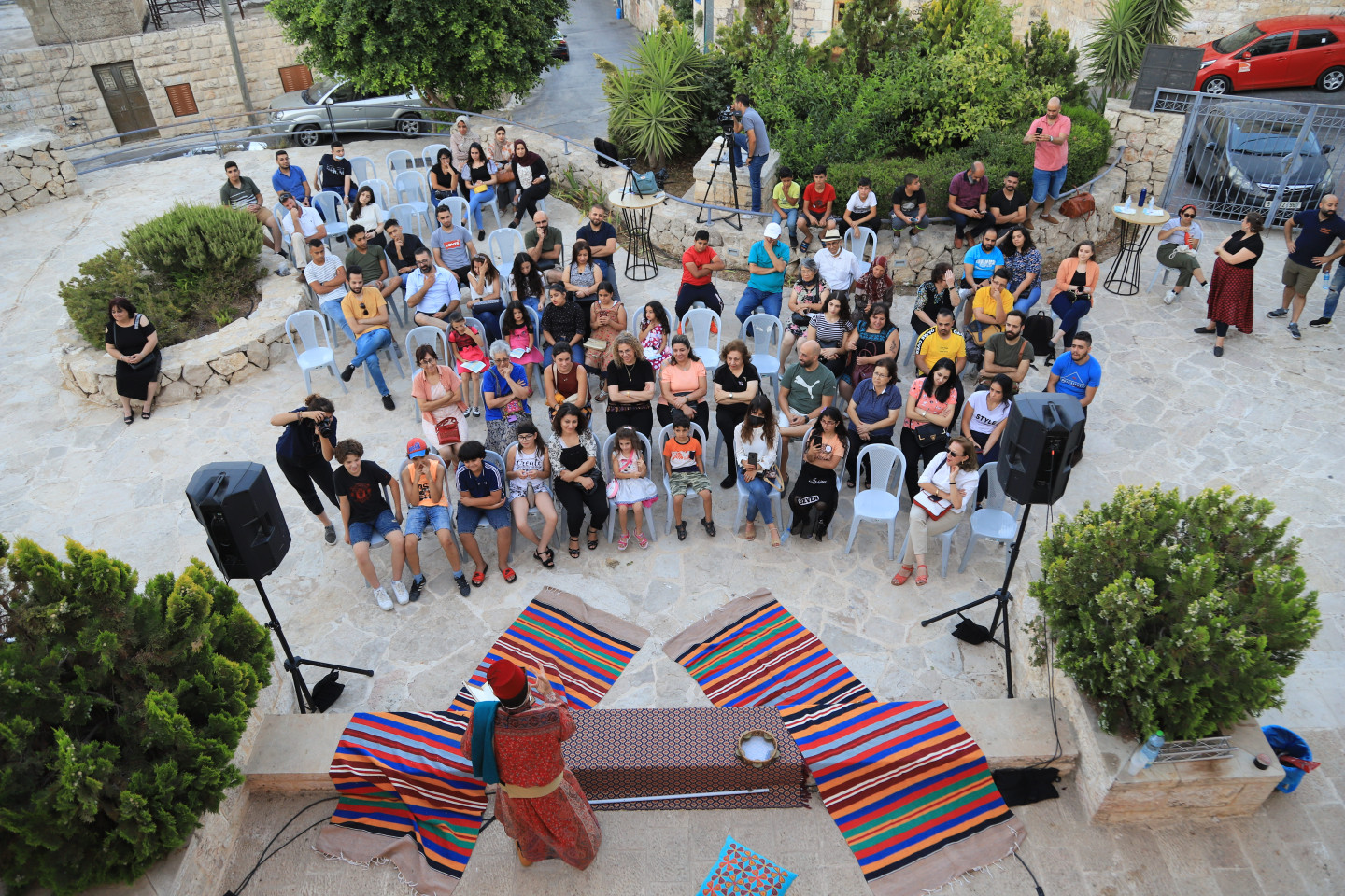 crowd watching an actor perform in a play on a stage.